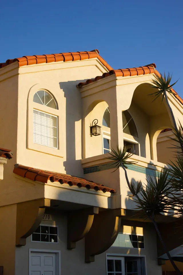 Sunlit tile roof on a stucco home, illustrative stock photography